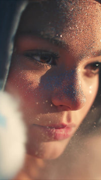 a close up portrait of a person with glitter on their face and blue background - Stock Video