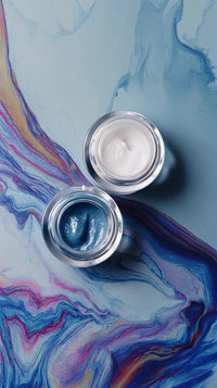 colorful marble background with two nail polish bottles on a surface one in front of the other against a blue background - Stock Video