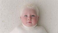 A Baby With Blonde Hair Is The Central Focus Of This Image Captured In A Close Up Shot Against A White Background — Stock Photo