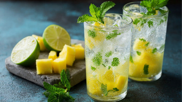 Two Glasses Of Mojito Cocktail With Lime Slices And Mint Leaves On A Blue Background — Stock Photo