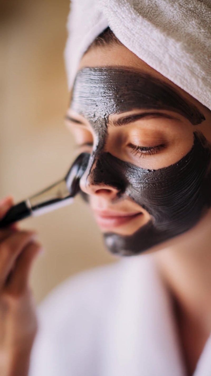 a woman applying a face mask in a spa setting - Stock Video