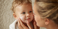 A Woman Lovingly Applying A Cream Lotion To A Baby S Face Capturing An Intimate Moment Between Them — Stock Photo