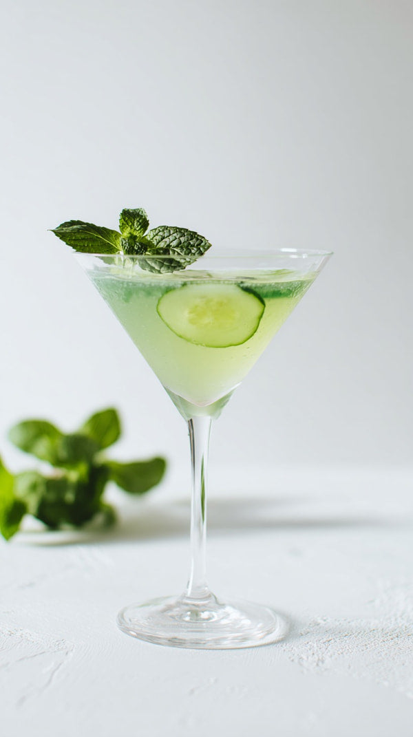 Displays A Martini Glass Filled With A Green Cocktail Garnished With A Slice Of Cucumber And A Sprig Of Mint — Stock Photo