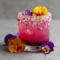 A Refreshing Raspberry Margarita Garnished With Edible Flowers Served In A Clear Glass On A Gray Surface — Stock Photo