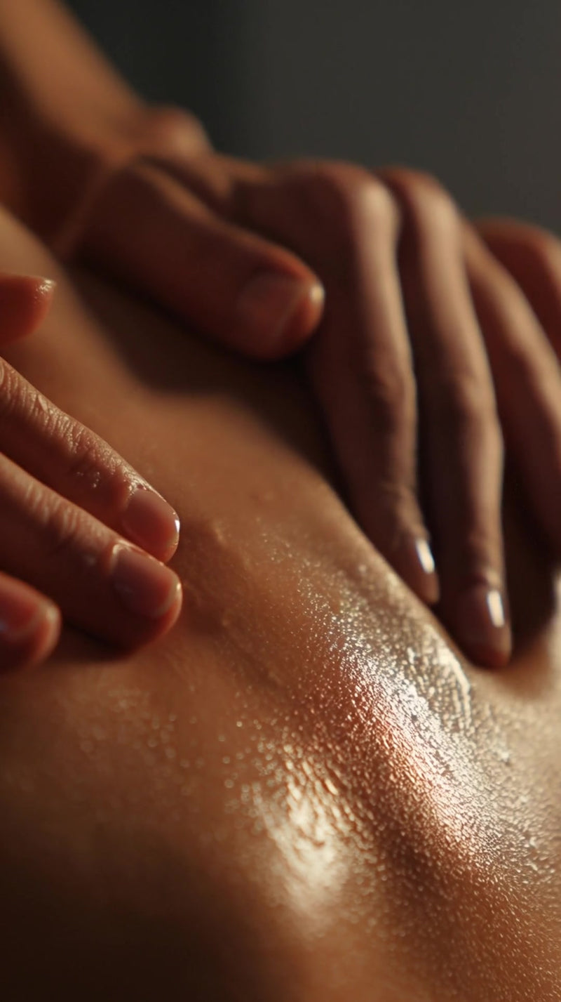 massage therapy session in progress with a person s back visible and hands applying oil lotion to the skin - Stock Video