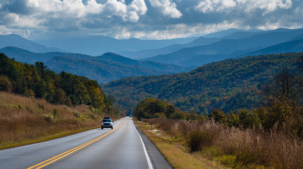 A Rural Highway With A Scenic View Of Mountains And Trees Captured From A Distance In Daylight — Stock Photo
