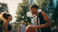 a young man is standing on a basketball court holding a basketball and smiling at two people who are looking at him - Stock Video