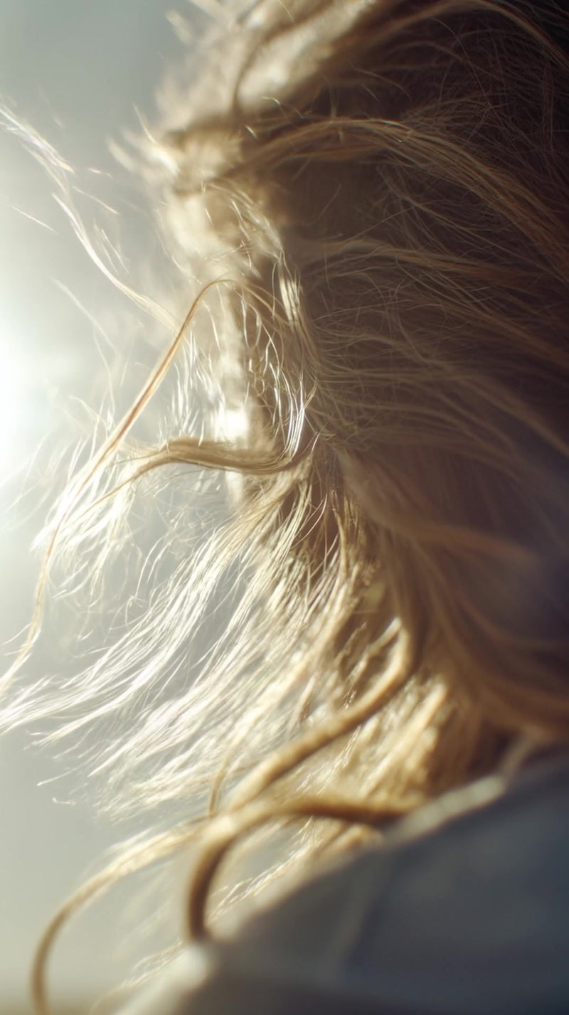 woman with long hair captured from behind as she walks outdoors with her hair caught mid motion by the wind - Stock Video