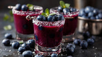 Three Glasses Of Blueberry Cocktails Garnished With Mint Leaves And A Sprinkle Of Sugar On A Dark Surface — Stock Photo