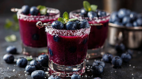 Three Glasses Of Blueberry Cocktails Garnished With Mint Leaves And A Sprinkle Of Sugar On A Dark Surface — Stock Photo