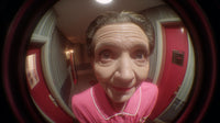 An Older Woman Stands In A Doorway Looking Directly Into The Camera With A Slight Smile On Her Face — Stock Photo