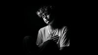 A Black And White Portrait Of A Person Sitting With Their Hand On Their Chest — Stock Photo