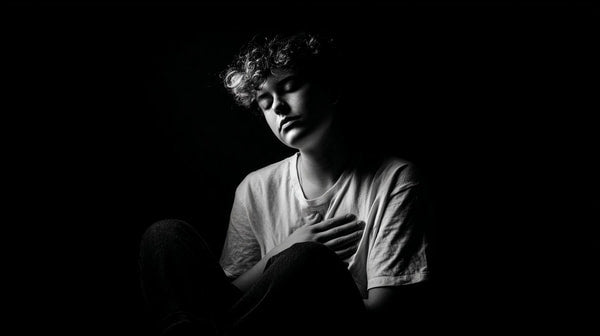 A Black And White Portrait Of A Person Sitting With Their Hand On Their Chest — Stock Photo