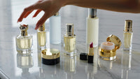 a collection of perfumes displayed on a table with various bottles and accompanying items such as a small brush and a small - Stock Video