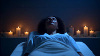 woman lying on massage table in dimly lit room with candles and white flowers - Stock Video