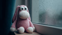 A Pink Stuffed Bunny Sits By A Window With Raindrops On It Looking Out Onto A Dark Street — Stock Photo