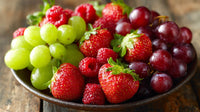 A Platter Of Fresh Fruit Including Grapes Strawberries And Melons Displayed On A Wooden Table — Stock Photo