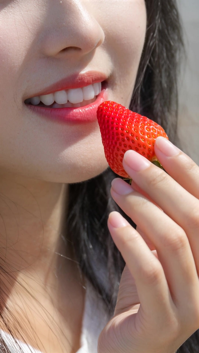 a woman enjoying a fresh strawberry in a close up shot - Stock Video