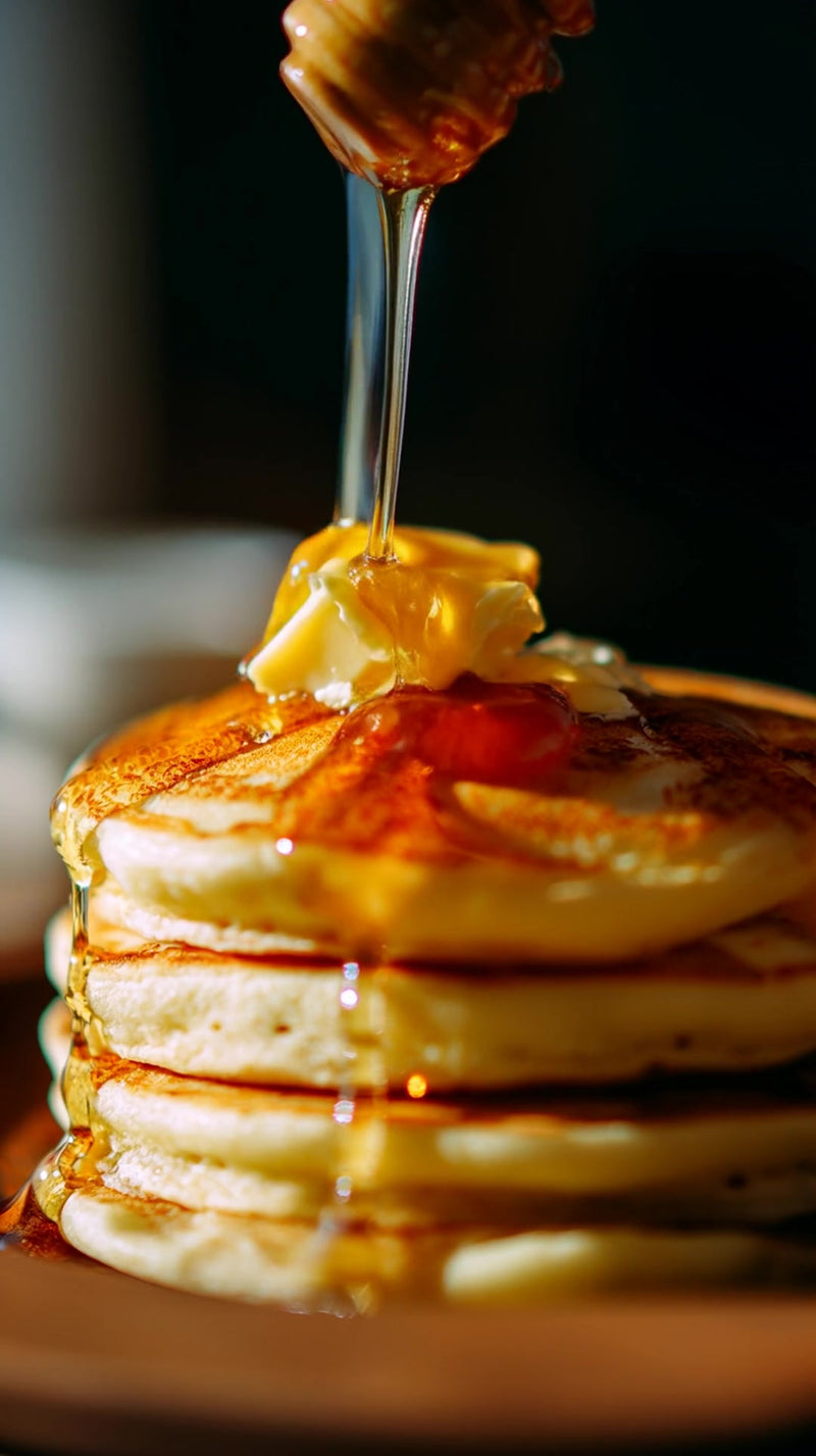 close up of a plate of pancakes with syrup and butter served on a wooden table - Stock Video