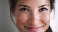 a woman with freckles is captured in a close up portrait showcasing her facial features and the freckles on her skin - Stock Video