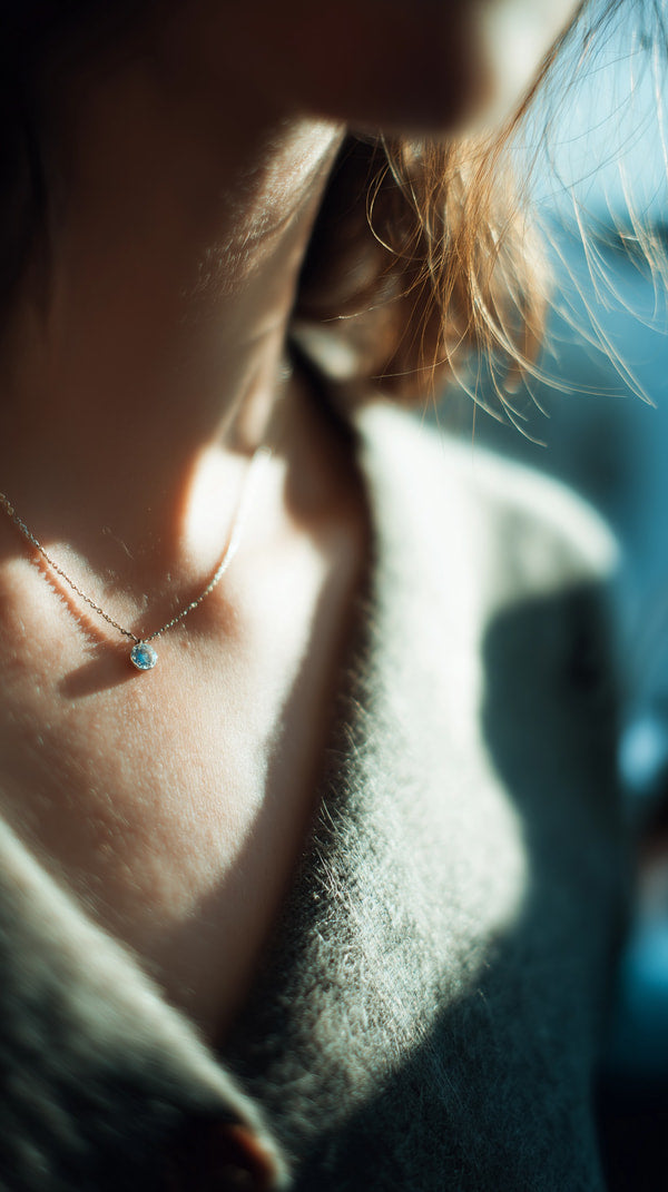 A Close Up Image Of A Woman Wearing A Necklace With Her Face Partially Visible In The Foreground — Stock Photo