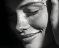 A Close Up Portrait Of A Woman With A Smile Captured From A Side Angle Against A Neutral Background — Stock Photo