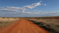 A Dirt Road In An Open Plain Under A Blue Sky With Clouds — Stock Photo