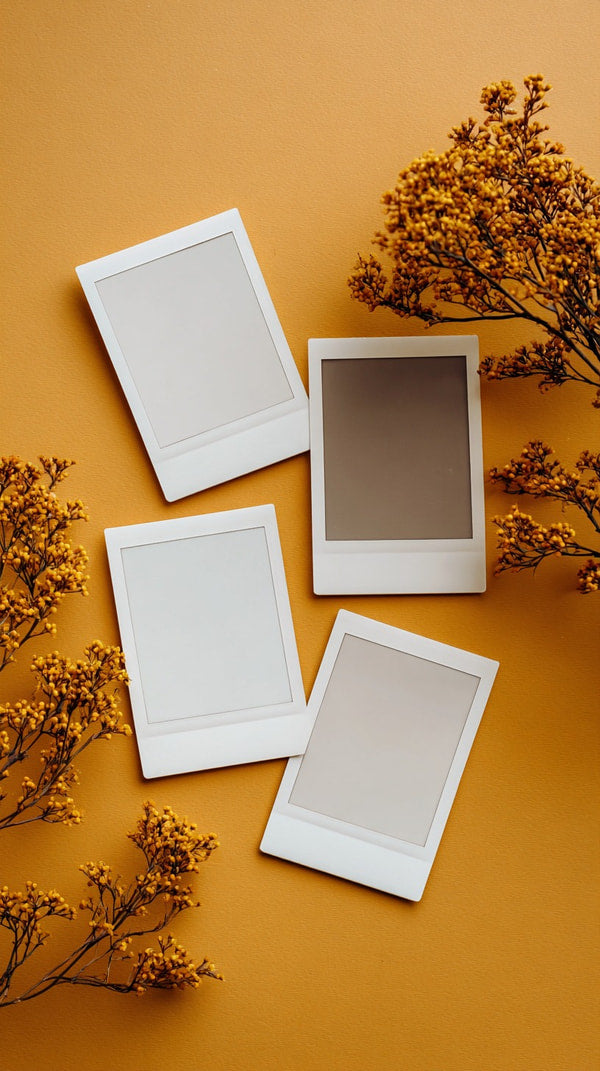 Four Polaroid Photos On A Table Arranged In A Square Formation Against A Blurred Background With Autumn Leaves And Branches — Stock Photo