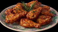 A Plate Of Chicken Wings Garnished With Parsley And A Sprig Of Rosemary Placed On A Dining Table — Stock Photo