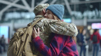 a soldier in uniform embraces a family member at an airport with both individuals smiling and appearing - Stock Video