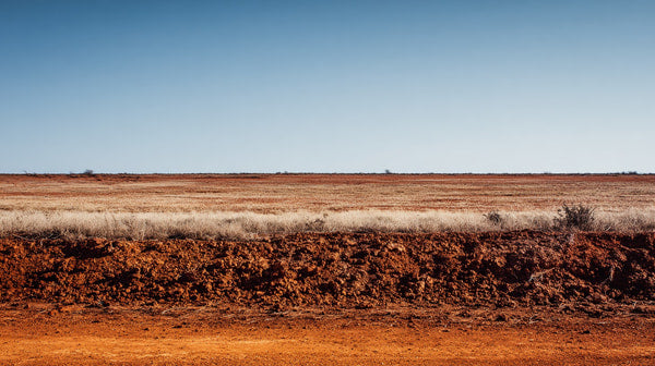 Aerial View Of A Dirt Road In The Australian Outback With Clear Blue Skies And Sparse Vegetation — Stock Photo