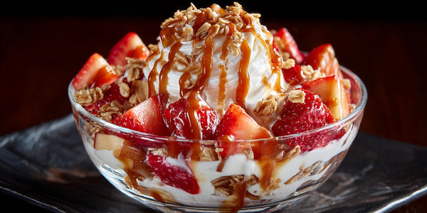 Strawberry Ice Cream Sundae With Whipped Cream And Nuts In A Glass Bowl On A Table — Stock Photo