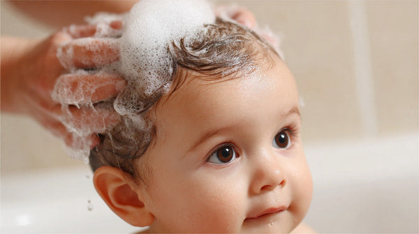 A Baby Being Washed With Soap And Water By An Adult In A Bathroom — Stock Photo