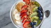 A Bowl Of Nutritious Breakfast Food Containing Yogurt Granola Bananas Strawberries And Blueberries Served On A Table — Stock Photo