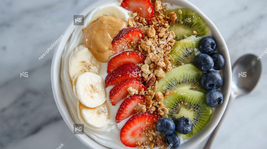 A Bowl Of Nutritious Breakfast Food Containing Yogurt Granola Bananas Strawberries And Blueberries Served On A Table — Stock Photo