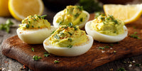 Six Deviled Eggs Garnished With Spices And Lemon Wedges On A Wooden Cutting Board — Stock Photo