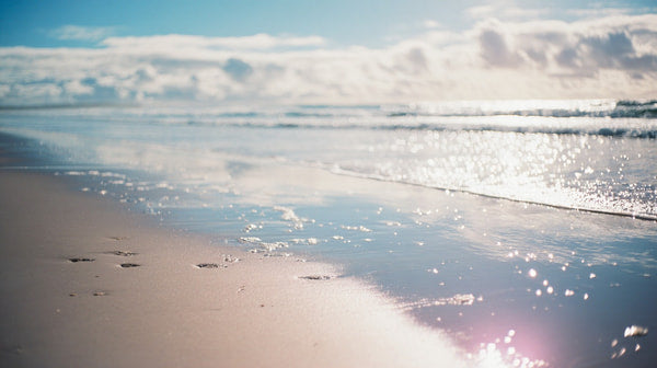 A Tranquil Beach Scene During Sunset With The Ocean S Edge Meeting The Horizon Under A Clear Sky — Stock Photo
