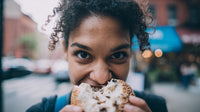 Woman Eating A Bagel In An Urban Setting — Stock Photo