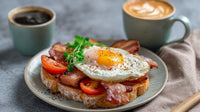 A Breakfast Sandwich With Fried Eggs On Toast Accompanied By A Cup Of Coffee And A Glass Of Orange Juice — Stock Photo