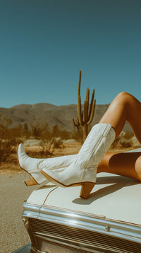 A Photograph A Person Sitting On The Hood Of A Vintage Car In A Desert Setting — Stock Photo