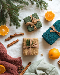 Gift Wrapping Supplies On A White Surface With Christmas Tree Branches And Oranges In The Background — Stock Photo