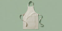 A White Apron With A Strap Displayed Against A Light Green Background — Stock Photo