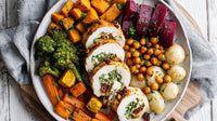 A Vibrant Plate Of Roasted Vegetables Chicken And Potatoes With A Garnish Of Parsley On A Wooden Table — Stock Photo