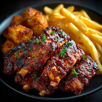 Two Plates Of Bbq Ribs And French Fries One With A Close Up View Of The Ribs Covered In Sauce And Garnished — Stock Photo
