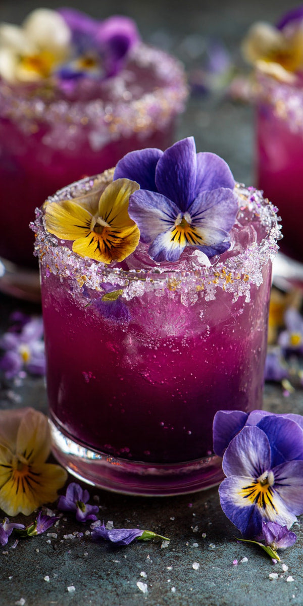Purple Flower Drinks Served In Mason Jars Garnished With Edible Flowers And Sprinkled With Sugar On A Dark Surface — Stock Photo
