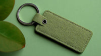 A Keychain With A Tag On A Green Surface — Stock Photo
