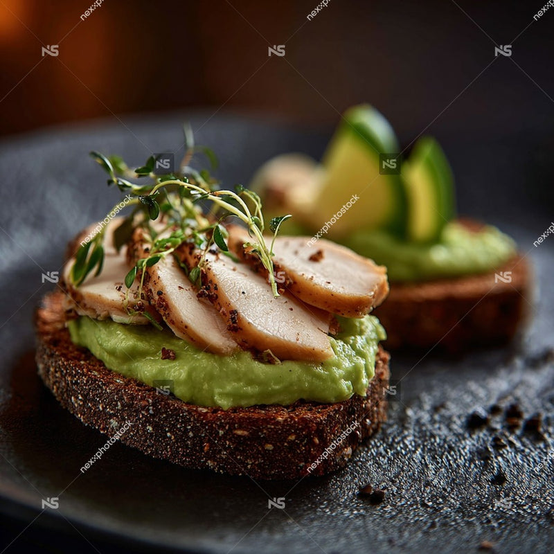 Gourmet Avocado Toast With Grilled Chicken Served On A Black Plate Topped With Fresh Herbs And A Wedge Of Lime — Stock Photo