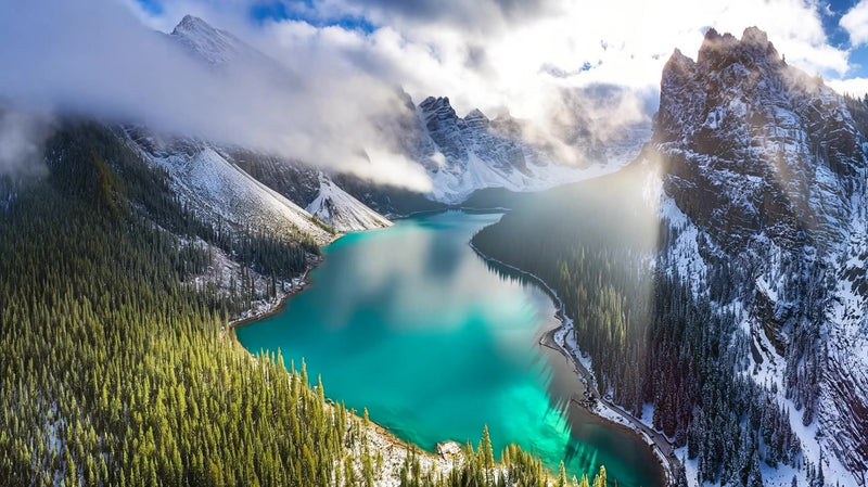 a aerial view of a snow capped mountain lake set against a clear blue sky - Stock Video