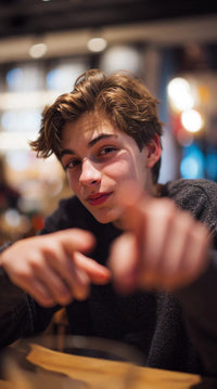 a young man is captured in a portrait style image pointing directly at the camera with his right hand - Stock Video