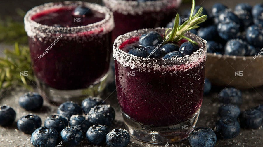Blueberry Margaritas With Salted Rims Garnished With Blueberries And A Sprig Of Rosemary Served In Glasses On A Table — Stock Photo